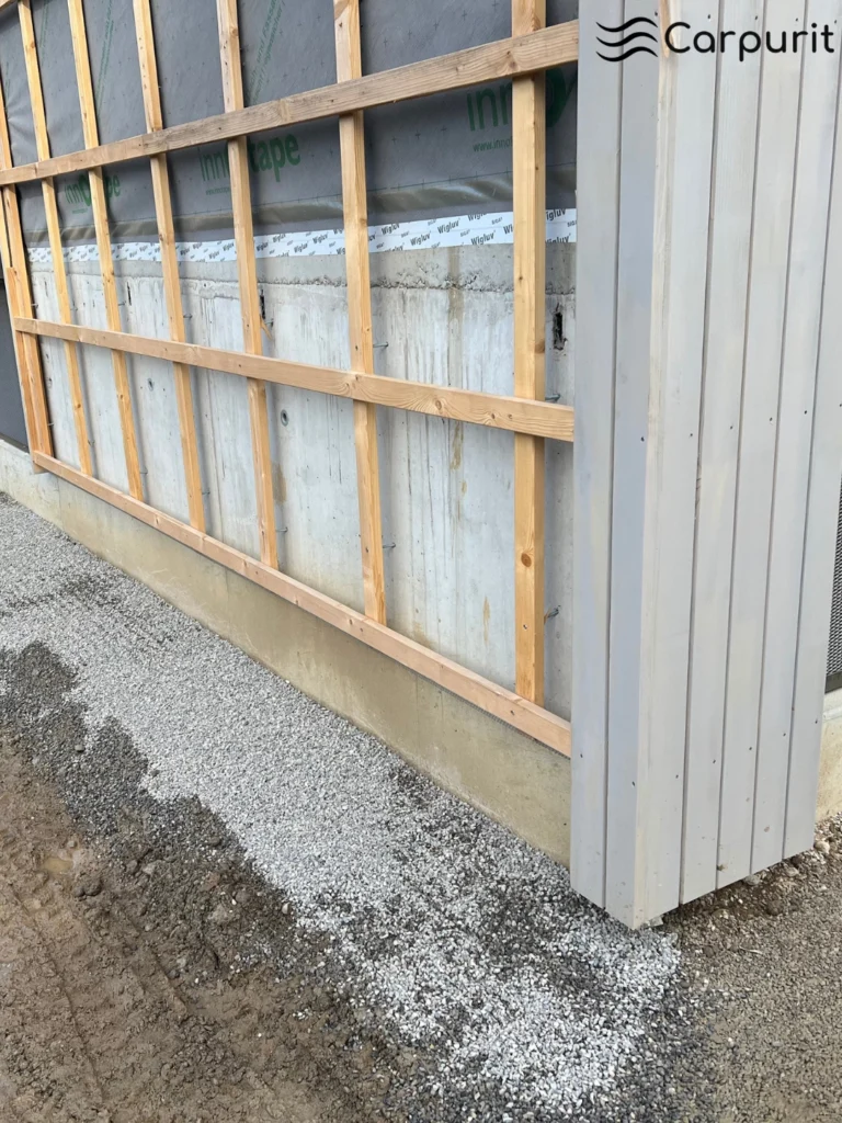 Fertig vorbereitetes, ebenes Kiesbett entlang der Fassade als stabile Basis für Ecoflow-Filtereinheiten.