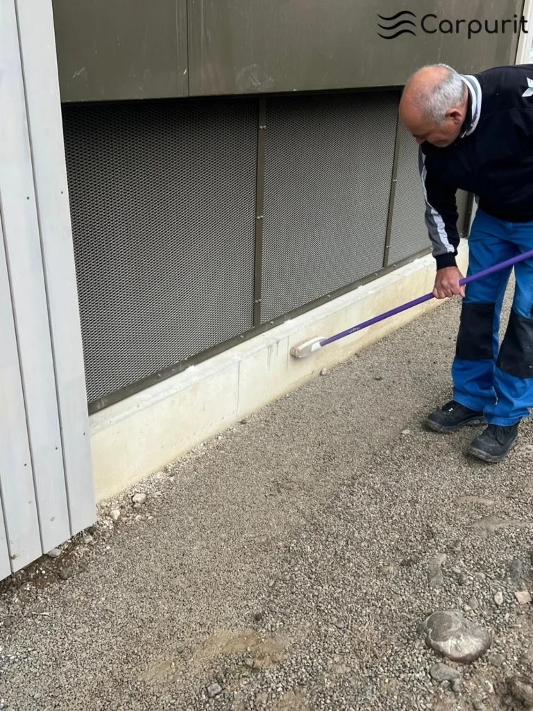 Vorbereitung des Kiesbetts entlang der Gebäudefassade als stabile Unterlage für die Carpurit-Filtereinheit.